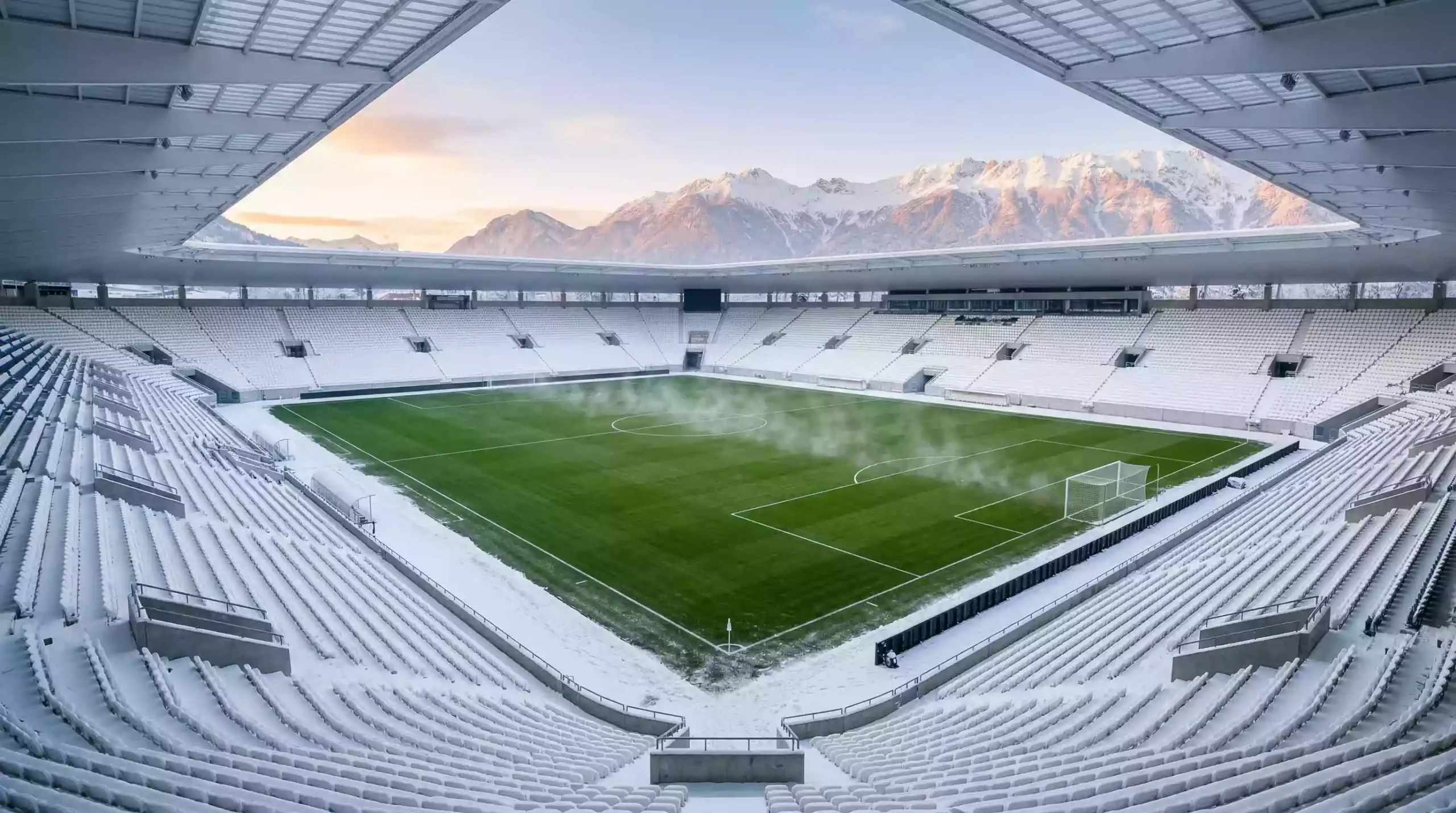 Estadio de fútbol japonés en invierno con nieve alrededor y el campo verde calefactado